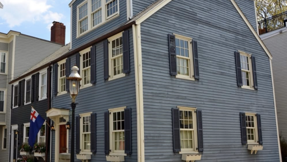 2 1/2 story wood clapboard house with side gable roof and stone foundation